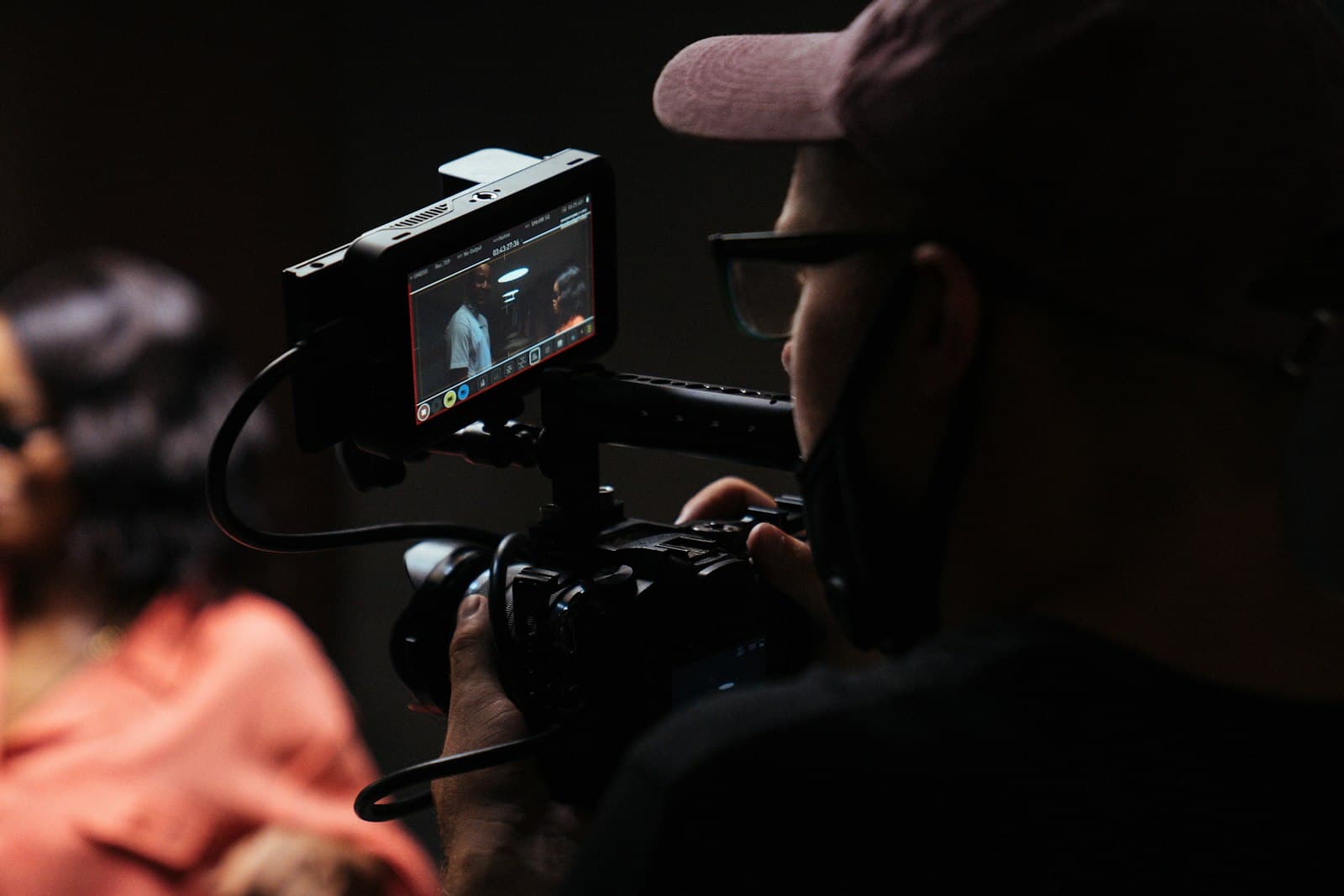 Un membre de l'équipe filme une production avec une caméra de cinéma et un moniteur de contrôle.