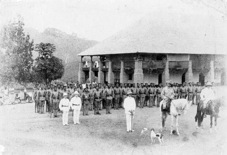 Groupe de soldats coloniaux allemands en uniforme, posant en rang à Ebolowa au Kamerun, début du XXe siècle.